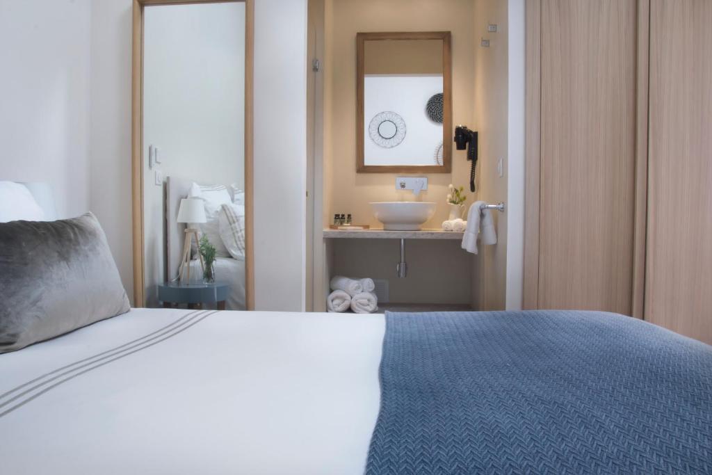 a bedroom with a bed and a bathroom with a sink at Boutique Hôtel Villa Fabulite in Antibes