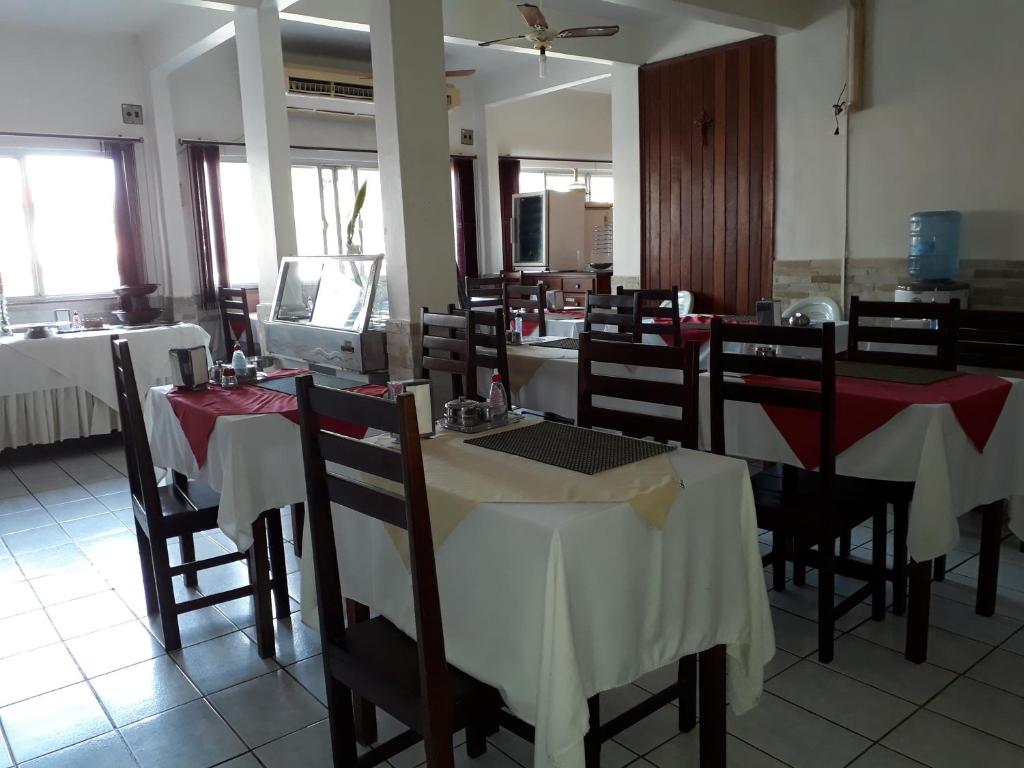um restaurante com mesas e cadeiras com toalhas de mesa vermelhas e brancas em Plaza Hotel em Marabá