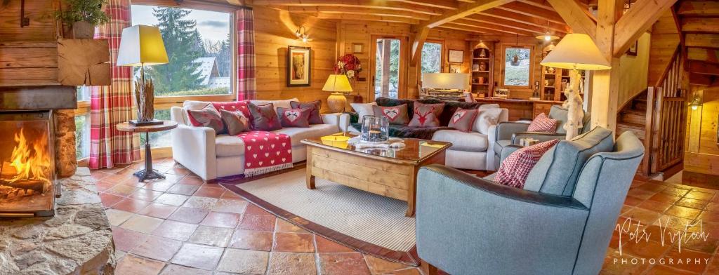 a living room with couches and a fireplace at Chalet Camomille in Les Gets