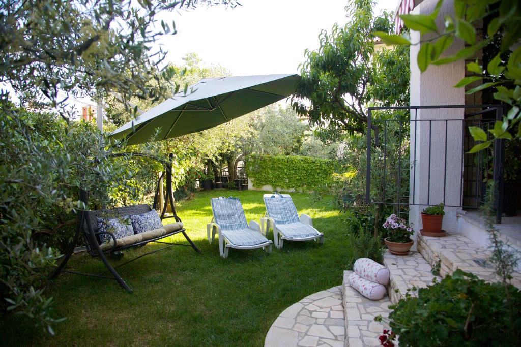 eine Terrasse mit 2 Stühlen und einem Sonnenschirm in der Unterkunft Melanija 2 in Rovinj