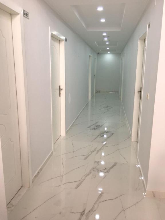 an empty hallway with marble floors and white walls at Julia Hotel in Sarandë