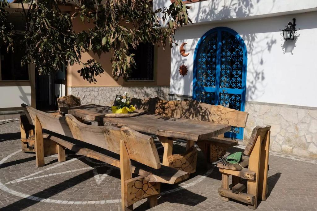 un tavolo in legno e panche di fronte a un edificio di Lemontree House Bacoli a Bacoli