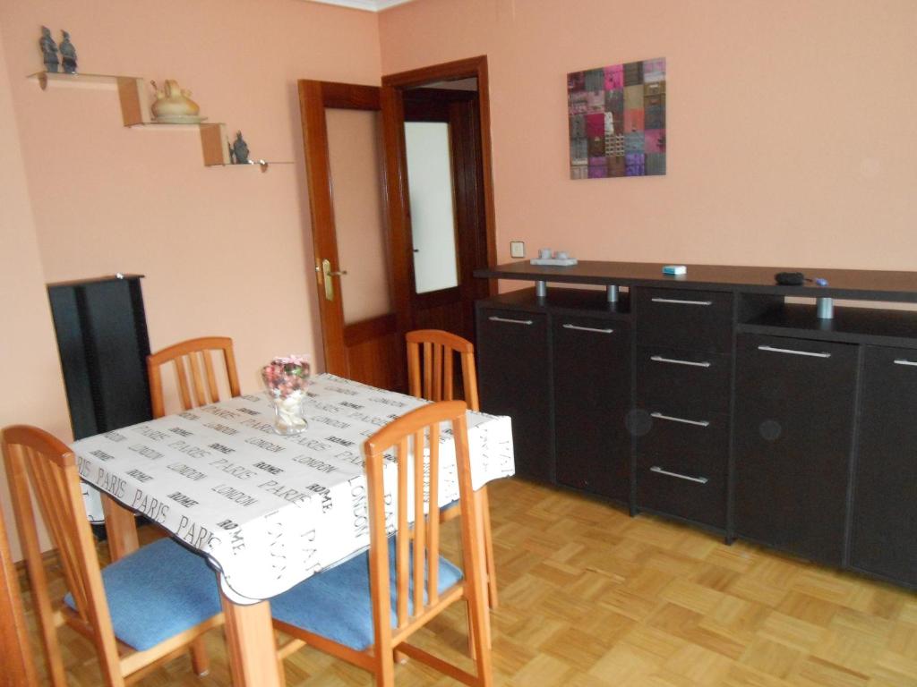 a kitchen with a table and some chairs and a table and a kitchen at San Blas in Santa Marta de Tormes