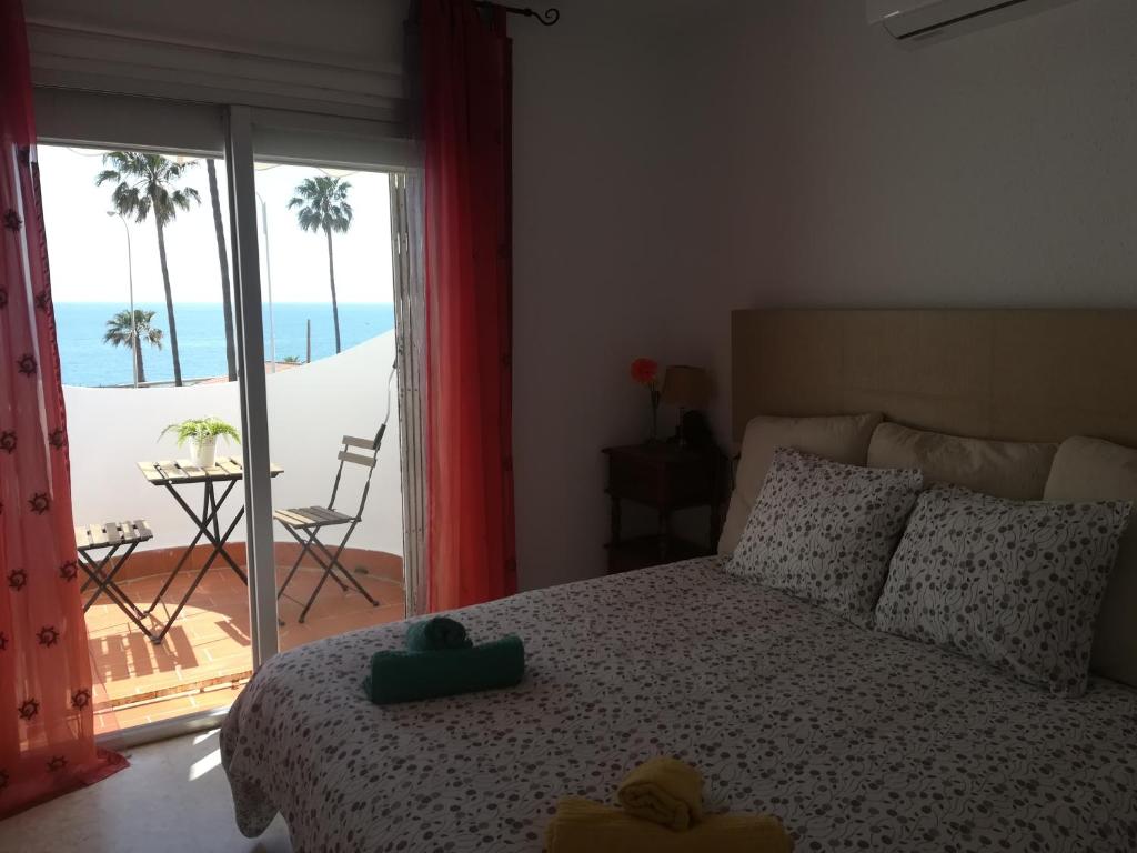 a bedroom with a bed with a view of the beach at Casa Las Toro Playa in Chilches