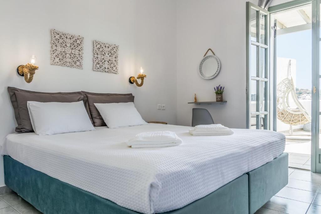 a white bedroom with a large bed with two white pillows at Sea Sun Sand Studios in Péran Triovasálos