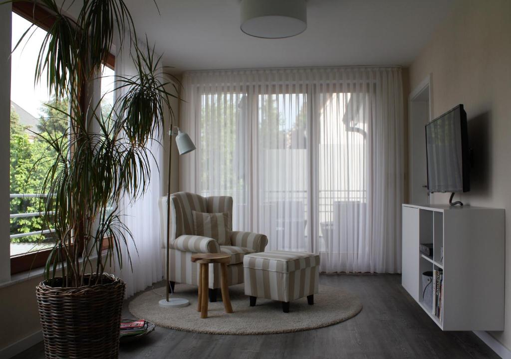 een woonkamer met een stoel en een televisie bij Die Stadtwohnung in Stadthagen