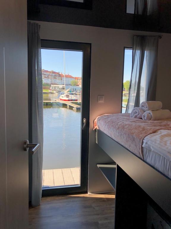 a room with a bed and a door with a window at Houseboat Porta Mare III in Świnoujście