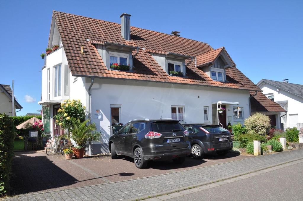 dois carros estacionados em frente a uma casa branca em DOUBLE Two Lodge em Kappel-Grafenhausen