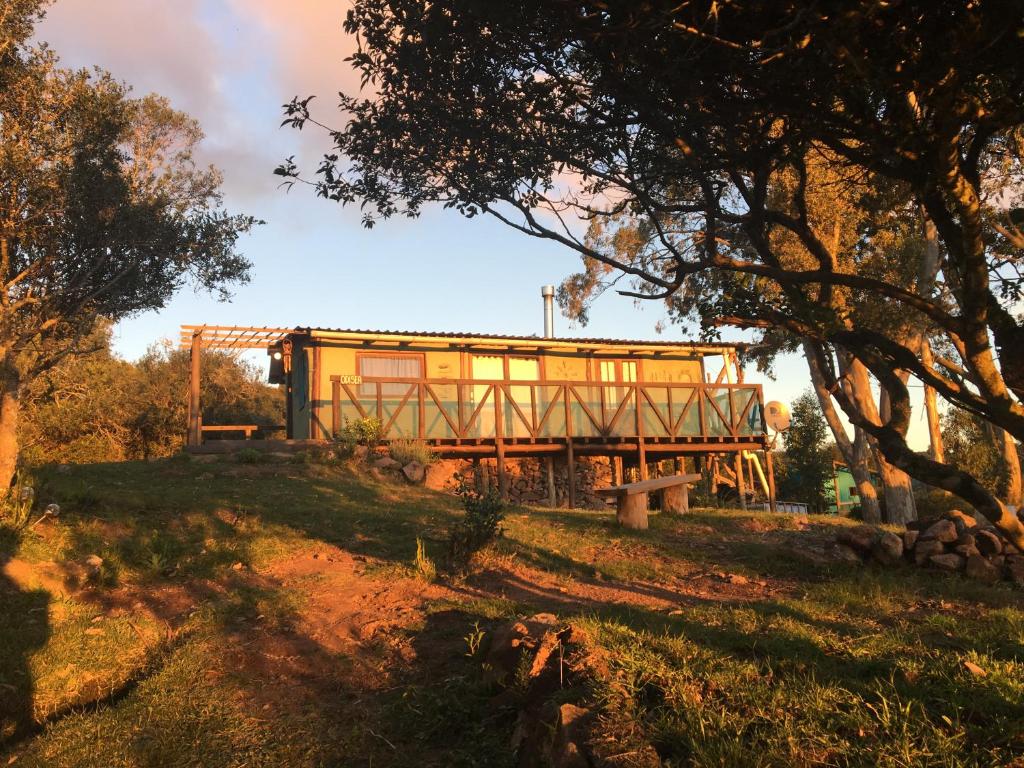 a yellow house on a hill with a bench at Odisea in Villa Serrana