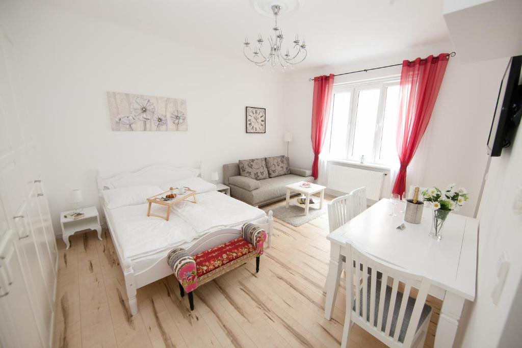 Cette chambre blanche comprend un lit et une table. dans l'établissement Traditional Apartments Vienna TAV - City, à Vienne