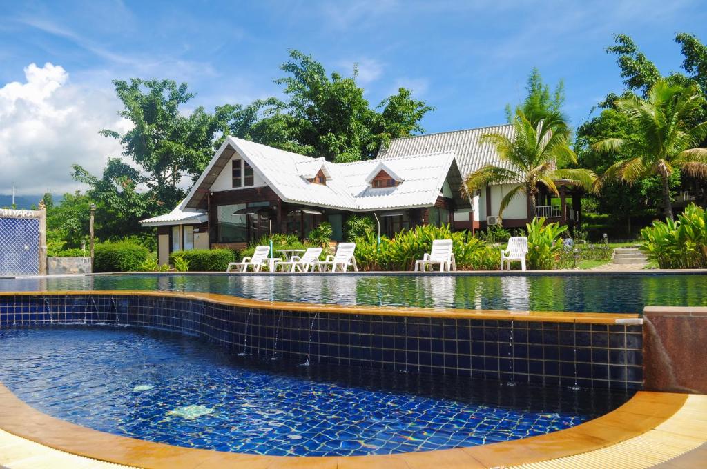 a swimming pool in front of a house at Pai Iyara Resort in Pai