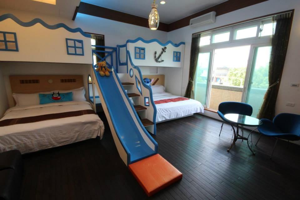 冬山鄉的住宿－美滿小窩親子溜滑梯城堡，一间卧室设有两张双层床和滑梯