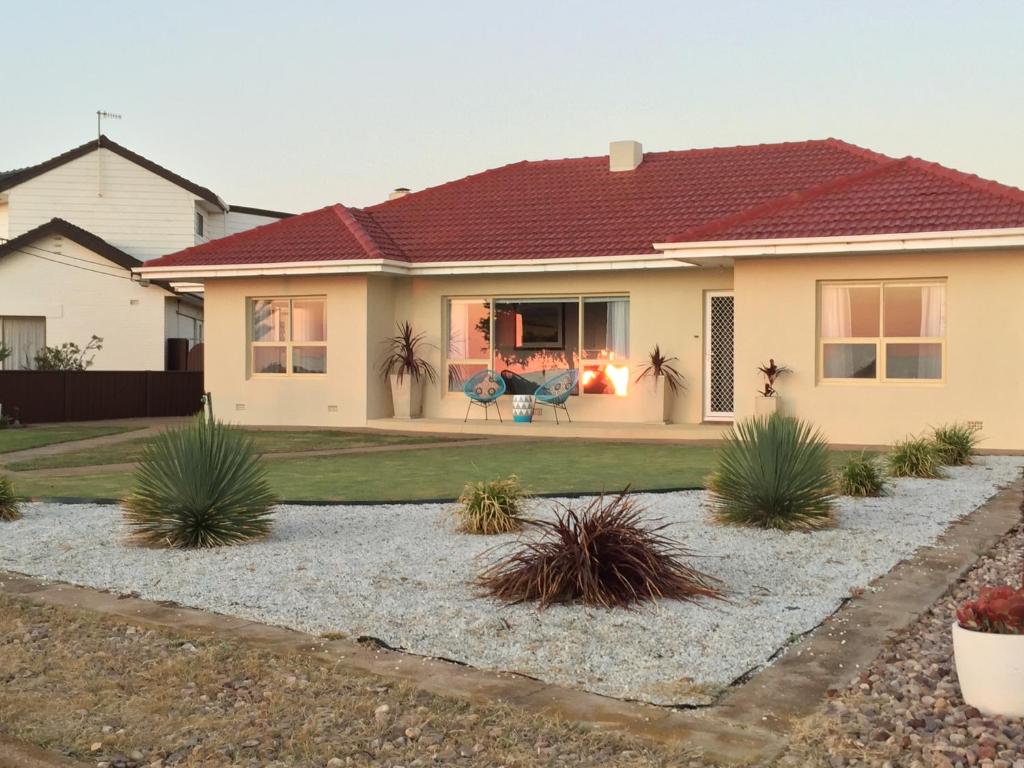 a house with a garden in front of it at Jewel of the South Beachfront Holiday Rental in Tumby Bay