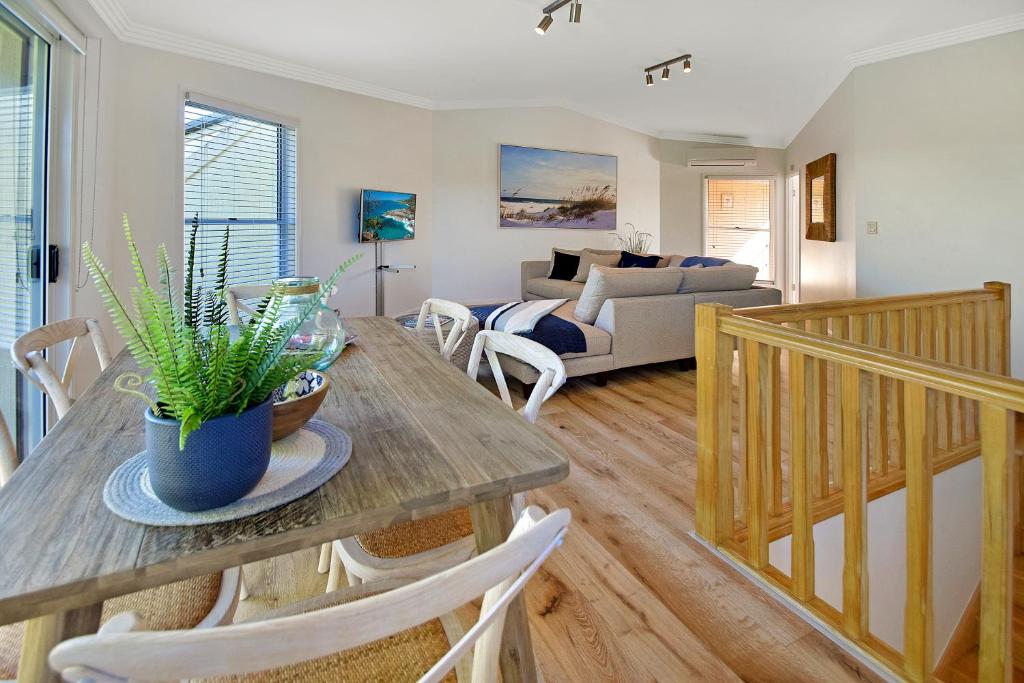 uma sala de estar com uma mesa e cadeiras e um sofá em Advance Place em Sunrise Beach