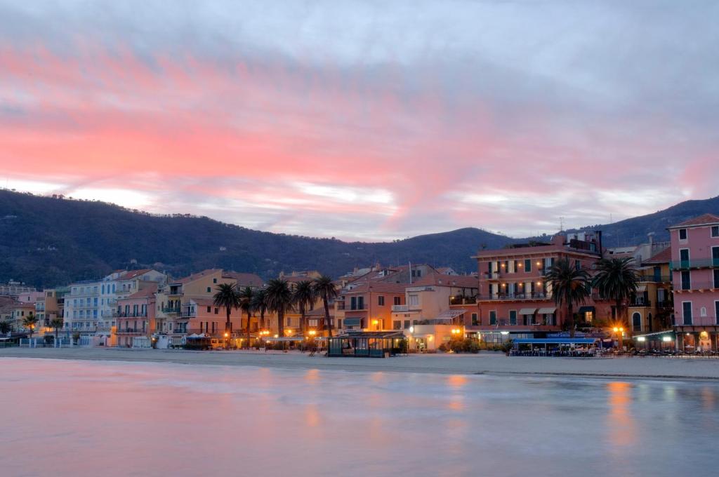 a city with buildings and palm trees on the water at Residence Le Terrazze in Alassio