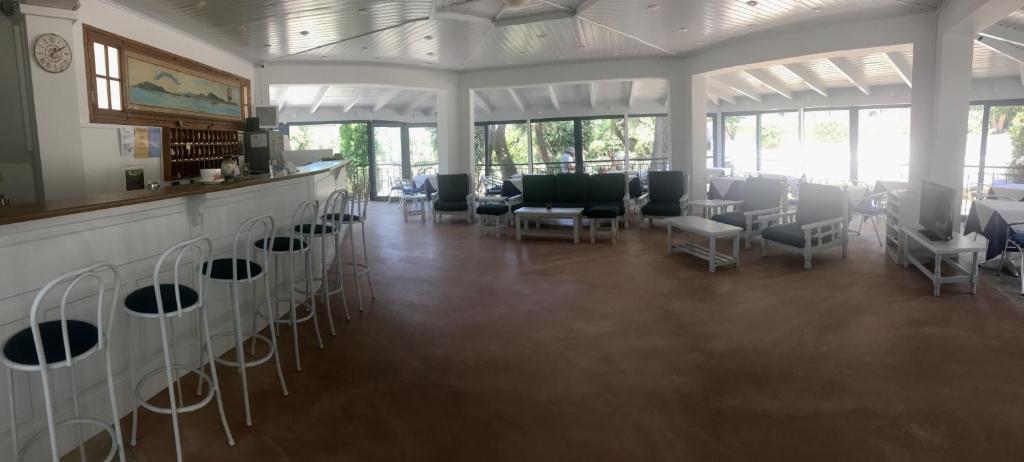 una grande stanza con sedie e un bar con finestre di Lofos Strani a Città di Zante