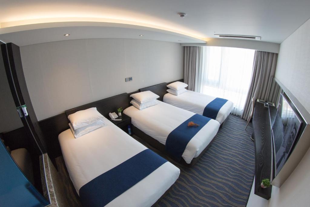 Postel nebo postele na pokoji v ubytování Gloucester Hotel Jeju