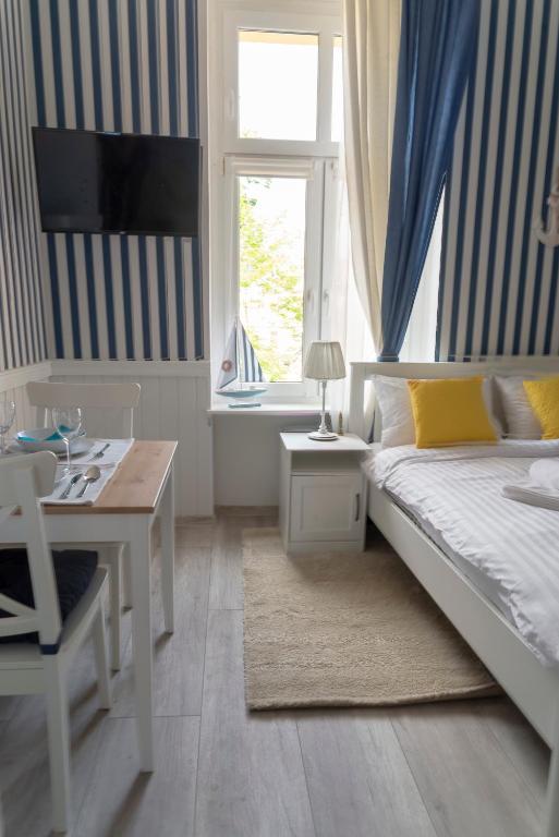 a bedroom with a bed and a desk and a window at Marina House Apartments in Międzyzdroje