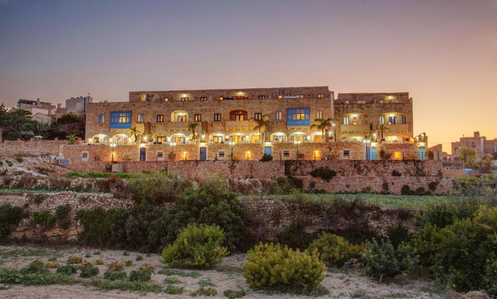 a large building on top of a hill at Carini Farmhouses in Għarb