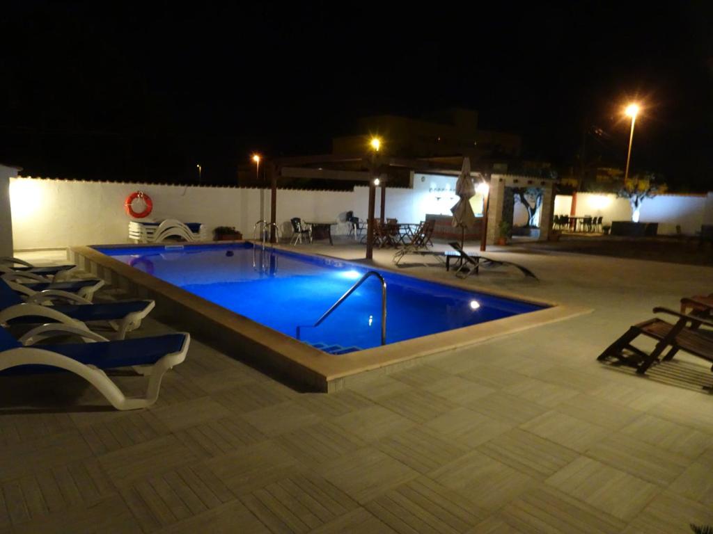 a swimming pool at night with chairs around it at Mi Naranjo (heated pool) in Orihuela Costa