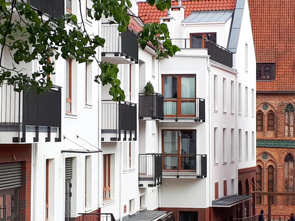 szereg białych budynków apartamentowych z balkonami w obiekcie Apartamenty Starówka - Riverside II w Szczecinie