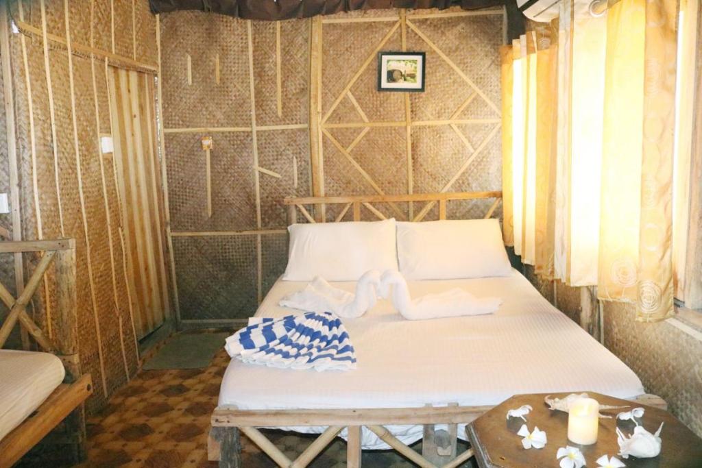 Bett in einem Zimmer mit Handtüchern darauf in der Unterkunft Scoop Cabana Kitesurfing in Kalpitiya