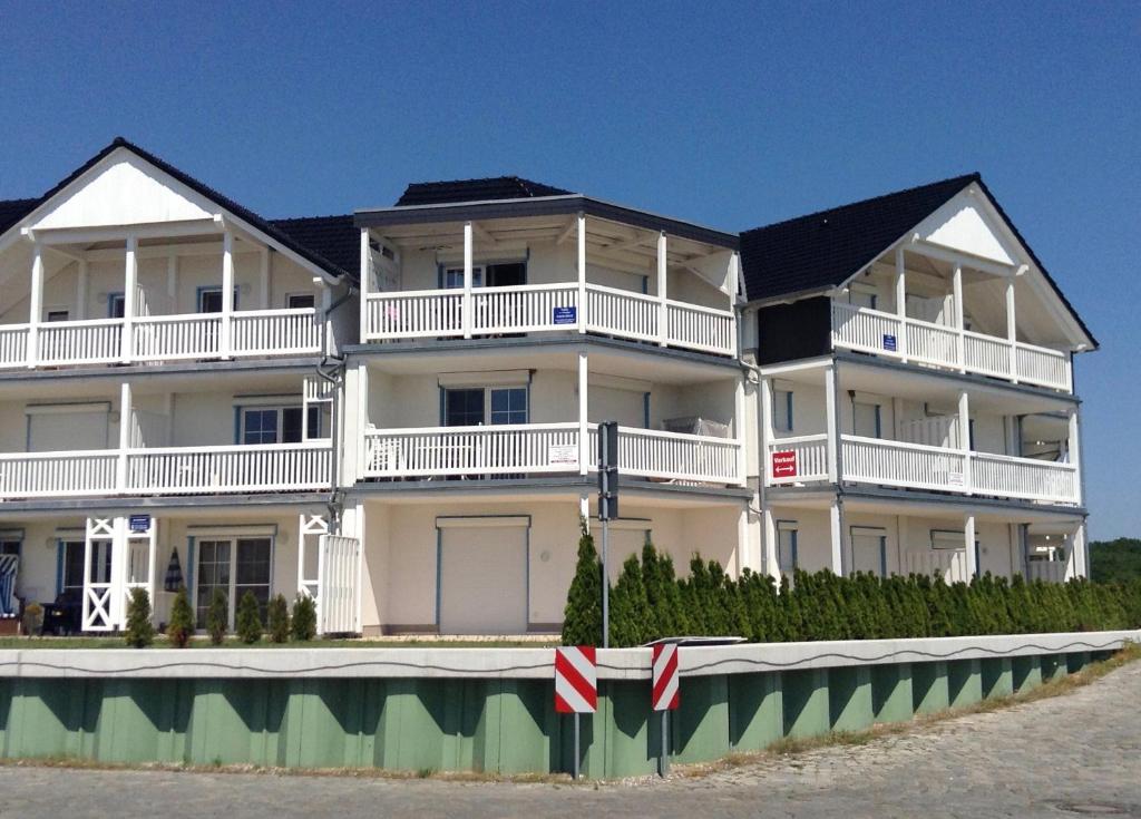 ein großes weißes Apartmenthaus am Strand in der Unterkunft Wohnen am Yachthafen in Ostseebad Karlshagen