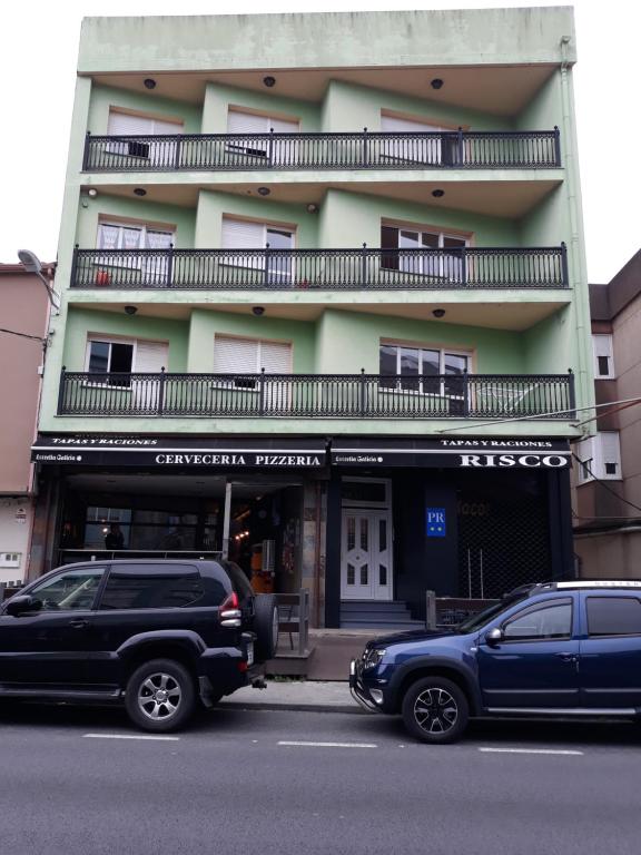 Vimianzo的住宿－Pensión Risco，两辆汽车停在大楼前