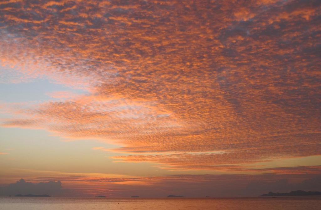 een bewolkte hemel boven de oceaan bij zonsondergang bij Beachfront TalingNgam in Taling Ngam Beach