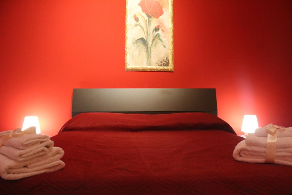 Un dormitorio rojo con una cama con dos luces. en B&B President Palace, en Riposto