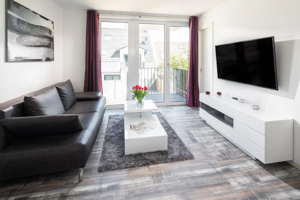 a living room with a couch and a tv at MeerZeit 8 - Norderney - Winterstraße 19 in Norderney