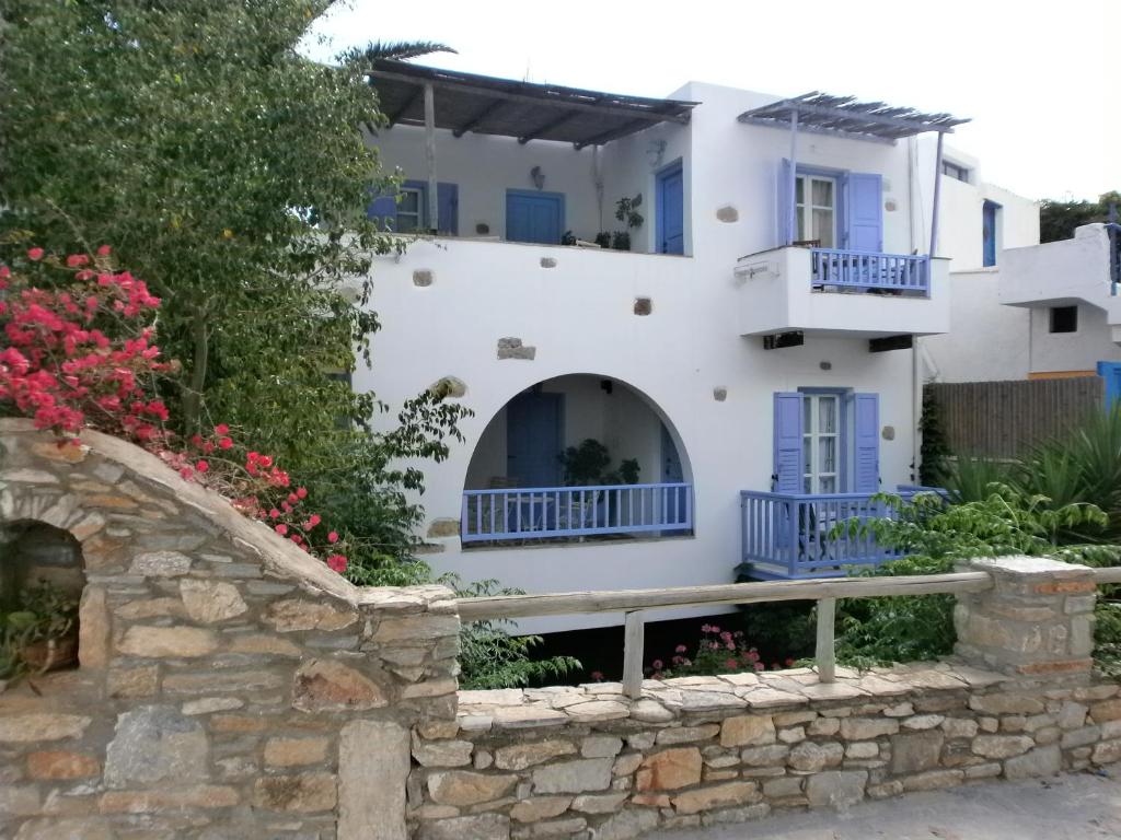 a house with blue windows and a stone wall at Amorgaia 1 in Katapola