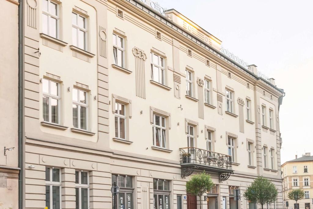 a large white building with windows on a street at Miodowa Boutique Residence in Krakow