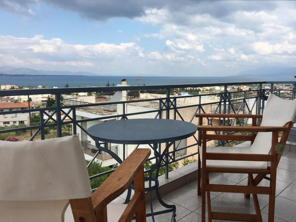 stół i krzesła na balkonie z widokiem na ocean w obiekcie Chalkida Beautiful Home with Stunning Views w Chalkidzie