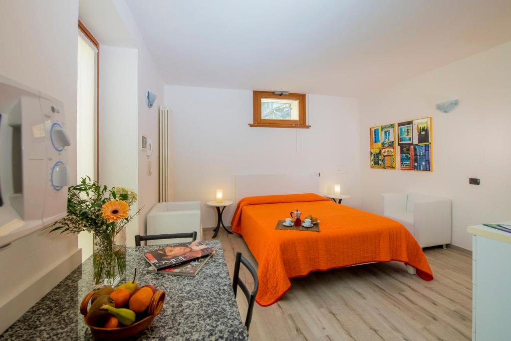 Cette chambre comprend un lit orange et une table. dans l'établissement Il Borgo, à Bellagio
