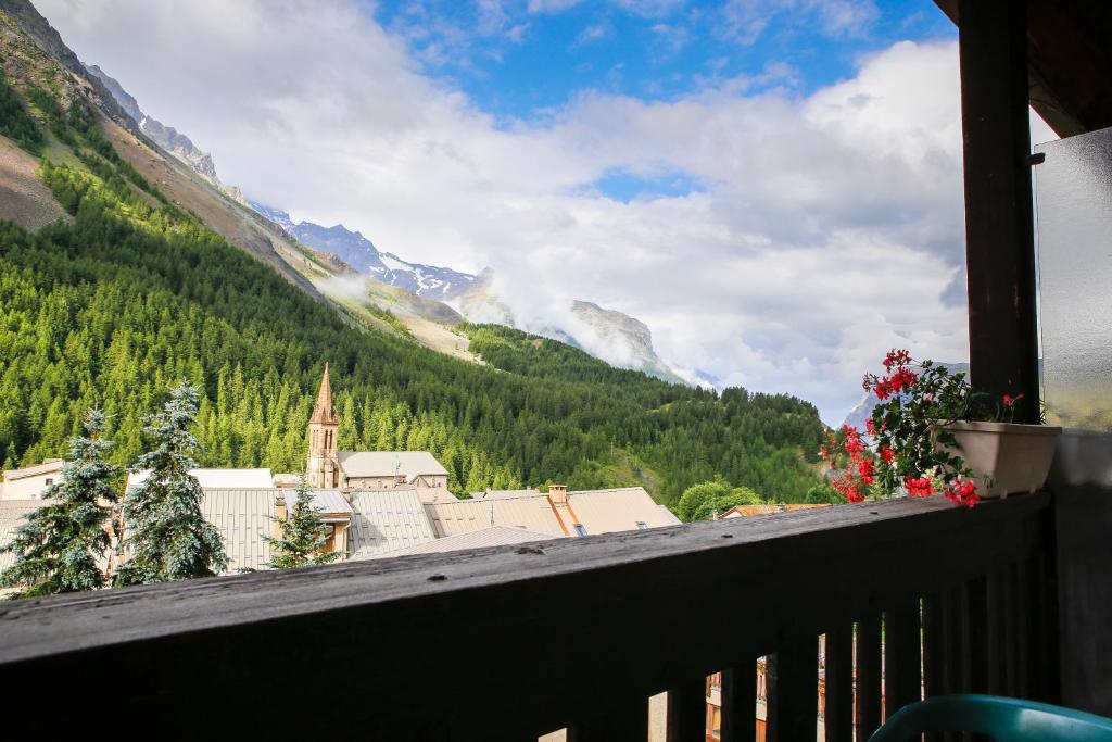 a balcony with a view of a town and mountains at Hotel Le Faranchin in Villar-dʼArène