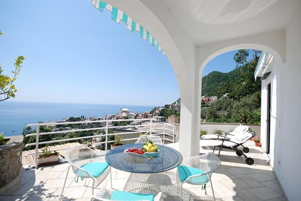 un patio con tavolo e sedie sul balcone. di fior di lino a Positano