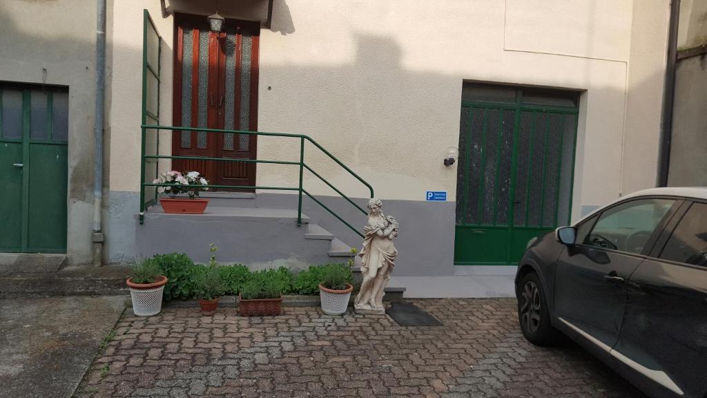 une voiture garée à côté d'un bâtiment avec portes vertes dans l'établissement Location Turistic Antica dimora di Campagna Cir 00012, à Grazzano Badoglio