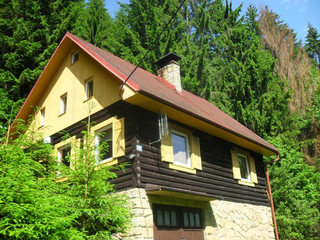 een houten huis met een rood dak bij Chata U skřítka in Valašská Bystřice