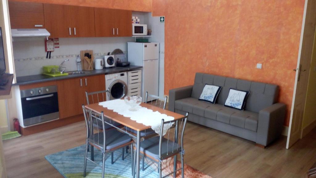 a kitchen and living room with a table and a couch at Apartamento da Ferreirinha in Peso da Régua