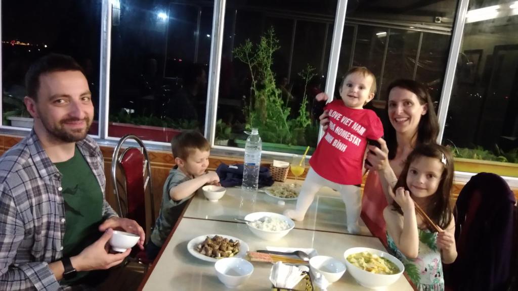 a family posing for a picture at a table with food at Sierra Homestay in Ninh Binh