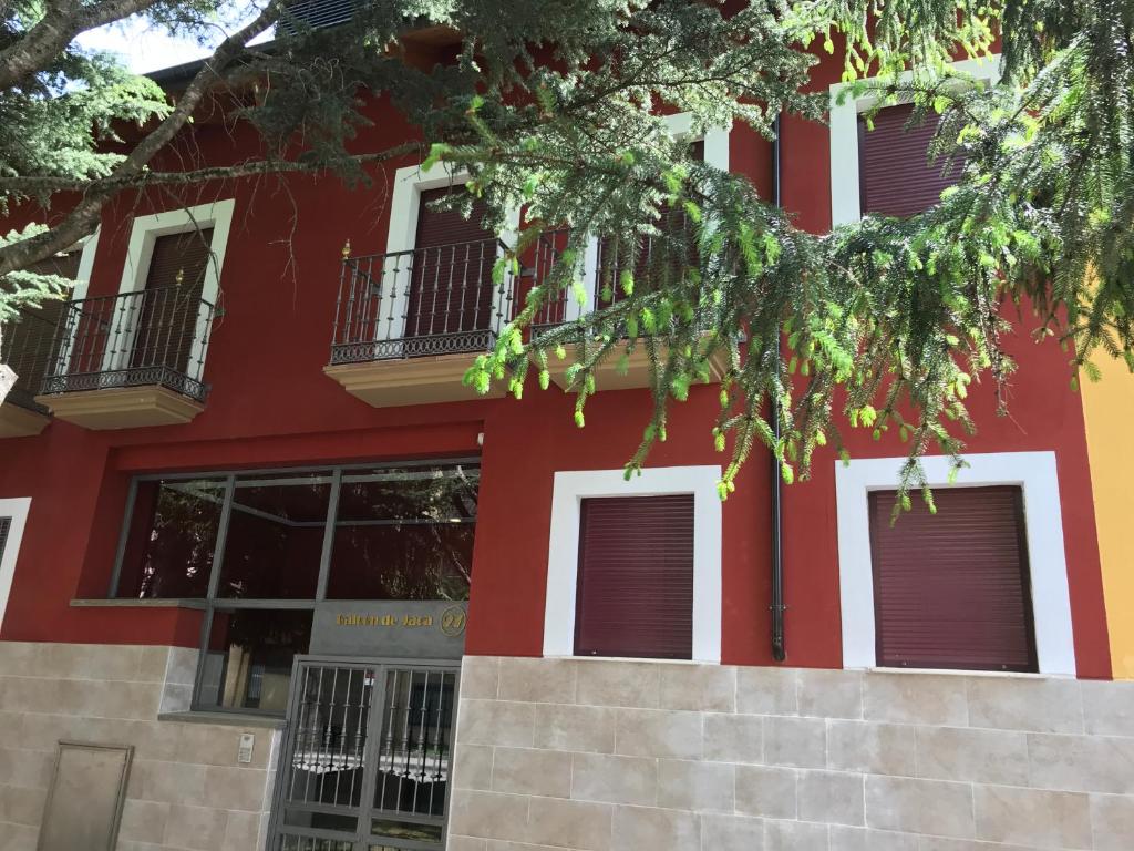 ein rotes Gebäude mit weißen Zierleisten und Fenstern in der Unterkunft Apartamento Balcon De Jaca I in Jaca