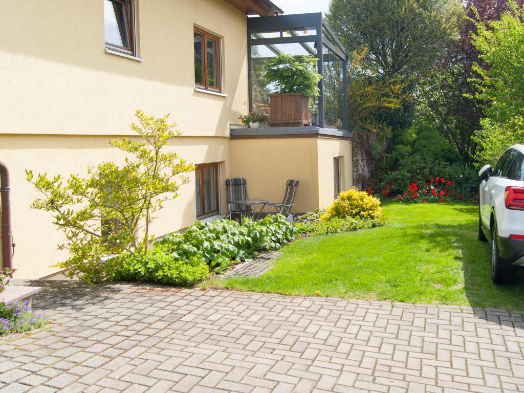 a house with a patio and a yard with flowers at Ferienwohnung über den Dächern von Dresden in Dresden