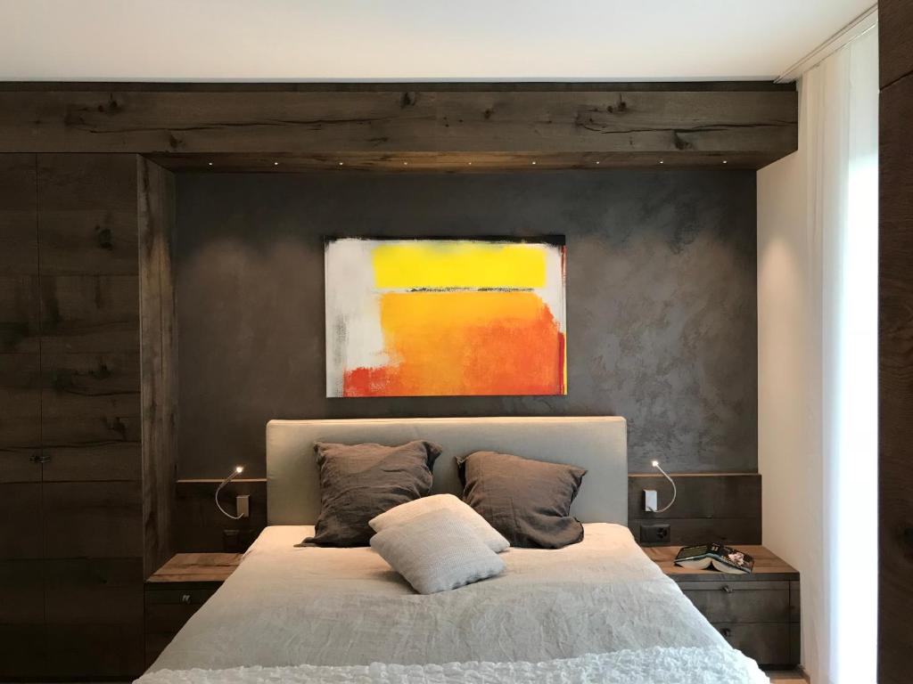 a bedroom with a bed with a painting above it at Appartement Suite Delta Resort in Ascona