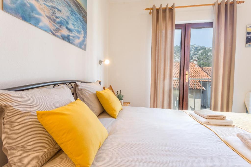 a bedroom with a bed with yellow pillows at So Hvar so Good! Spacious with terrace in Hvar