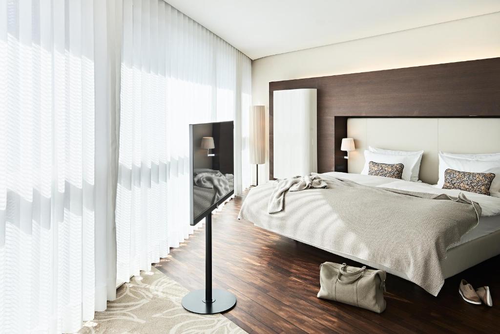 a bedroom with a large bed and a large window at SIDE, Hamburg, a Member of Design Hotels in Hamburg