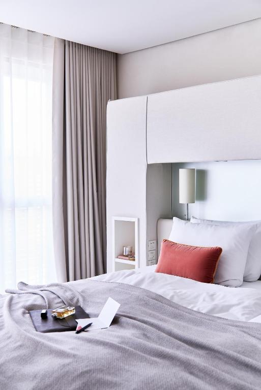 a bedroom with a large bed with a red pillow at SIDE, Hamburg, a Member of Design Hotels in Hamburg