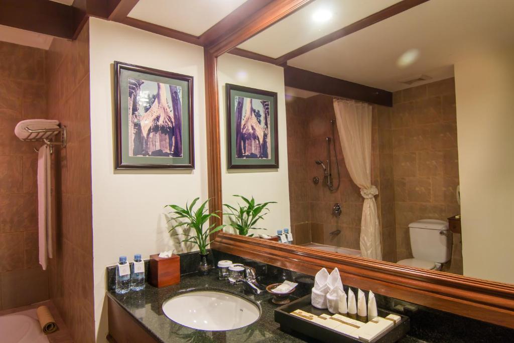 a bathroom with a sink and a toilet and a mirror at Palace Residence & Villa Siem Reap in Siem Reap