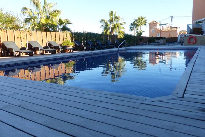 a swimming pool with chairs next to a building at Albir Palace in Albir