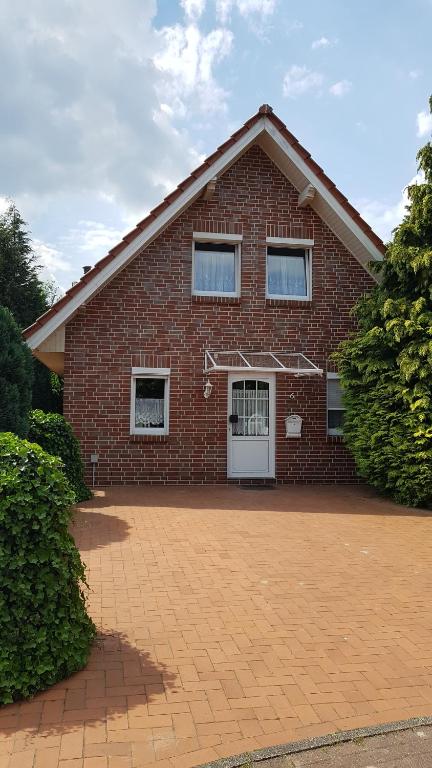 una casa de ladrillo rojo con puerta blanca en Ferienhaus am Alfsee, en Rieste